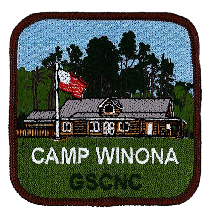 Embroidered patch depicting a log cabin, trees, a flagpole with a red and white flag, and text reading CAMP WINONA GSCNC on a green background, all within a brown border—a charming tribute to Girl Scout dedication at Camp Winona.